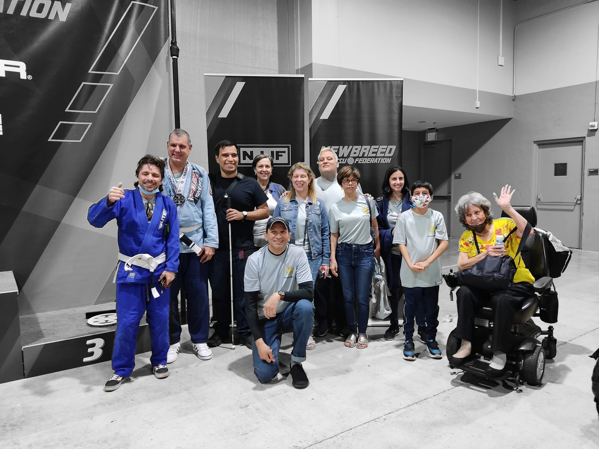 Community members supporting Brazilian Jiu-Jitsu athletes at an event